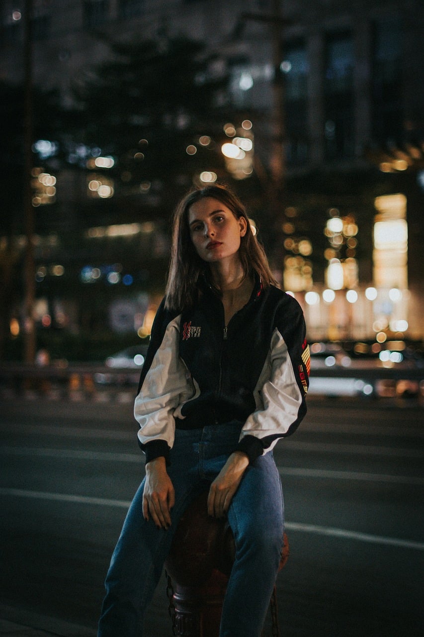 Model posing on a city street at night